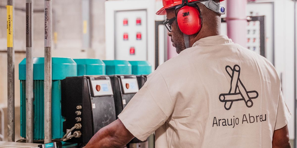 Colaborador da Araujo Abreu fazendo manutenção em máquinas de uma fábrica.